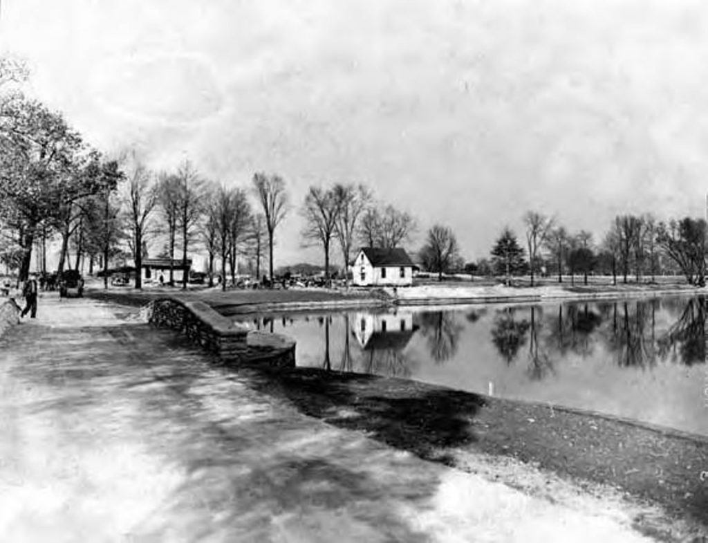 History of East Cleveland: 1938: John D. Rockefeller donates his estate to the city to become Forest Hill Park | Historic photo of the park showing a lake, stone bridge and multiple small buildings
